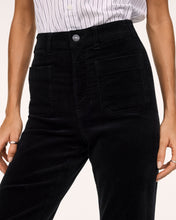 Load image into Gallery viewer, Close-up detail of high-rise black corduroy bootcut pants with front patch pockets and silver button