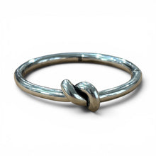 Load image into Gallery viewer, Polished silver bangle bracelet featuring a sculptural knot detail at the front