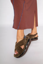 Load image into Gallery viewer, Model wearing fuzzy crossover strap sandals with dark brown sole and blue buckle detail