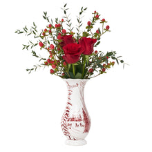 Load image into Gallery viewer, White ceramic vase with red winter toile pattern holding red roses and berry branches