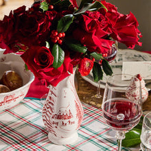 Load image into Gallery viewer, White ceramic vase with red winter toile scene holding red roses on a holiday table setting