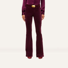 Load image into Gallery viewer, High-rise flare velvet pants in deep burgundy worn with matching satin blouse and gold belt