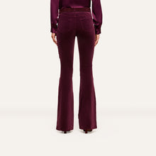 Load image into Gallery viewer, Back view of high-rise velvet flare trousers paired with a satin blouse on model