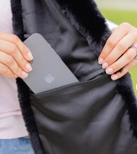 Load image into Gallery viewer, Woman placing an iPhone into the hidden interior zippered pocket of a faux fur scarf